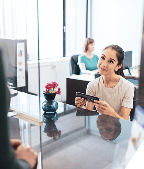 Receptionist receiving insurance card of patient