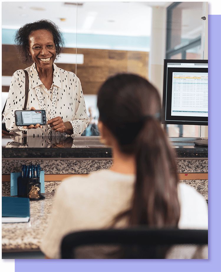 woman showing insurance card at front desk of provider