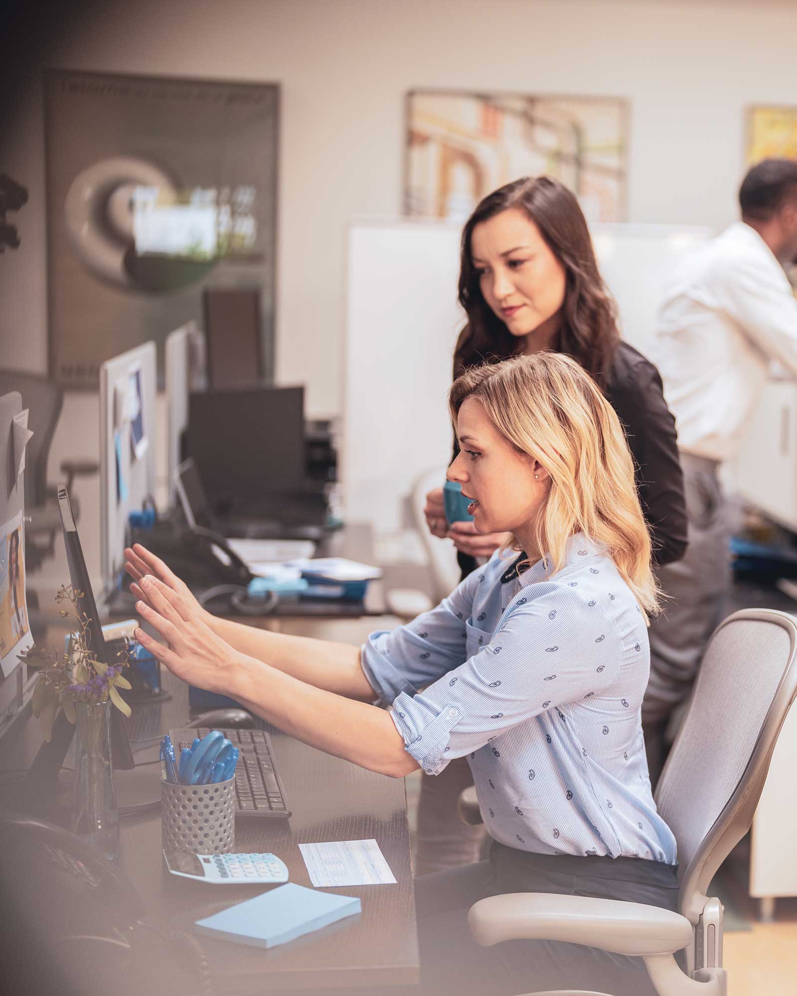 Coworkers discussing Bill Review at computer