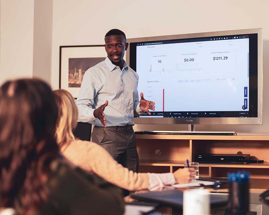 Man presenting in front of a television